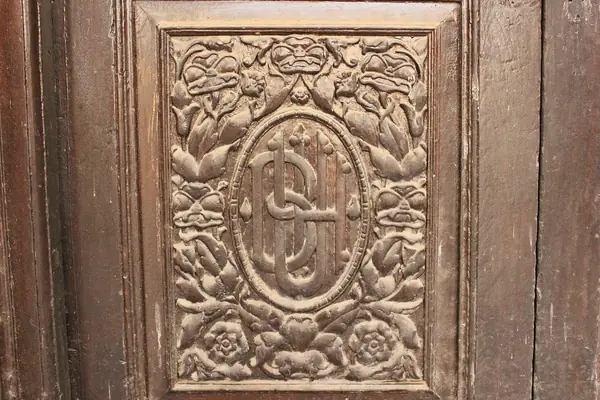 Detail of a hand-carved wooden door panel with floral relief