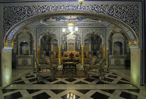 Formal Indian drawing room with gilded columns and patterned stone flooring