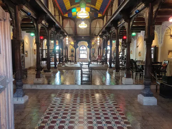 Long pillared hall with timber columns and a patterned tile floor